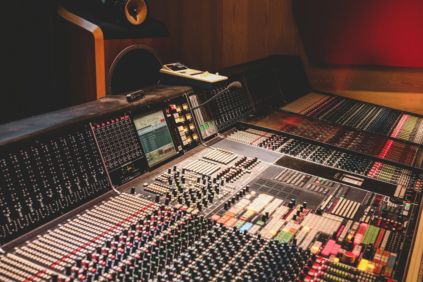 Console de mixage audio avec faders et boutons dans un studio d'enregistrement.