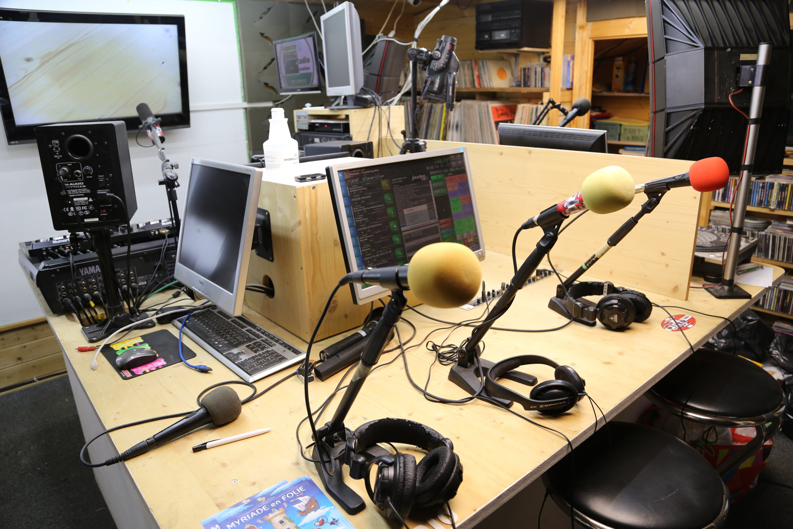 Un microphone classique posé sur un bureau en bois poli dans un studio.