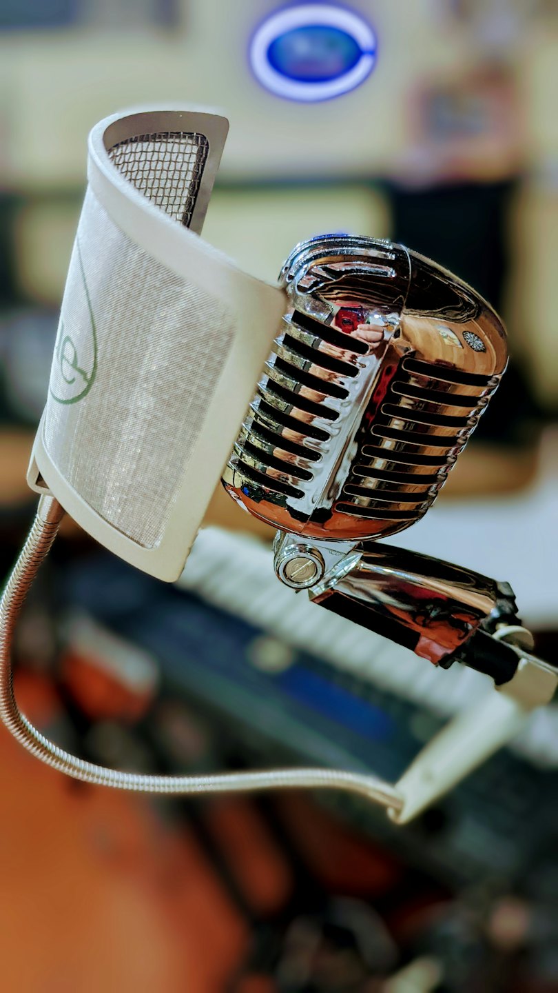 Un microphone chromé vintage sur un pied de studio d'enregistrement.